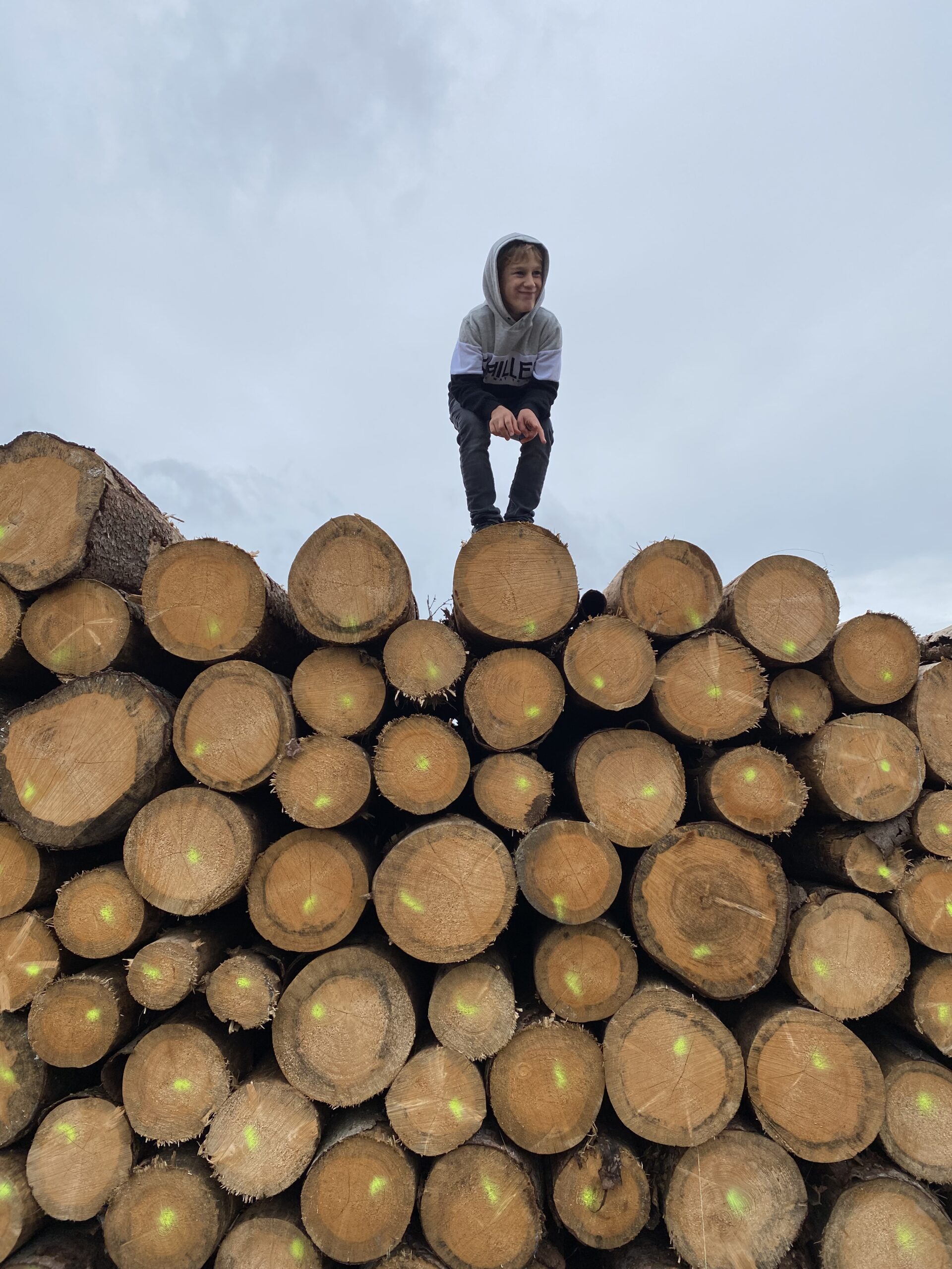 Boy on a pile of lumber.