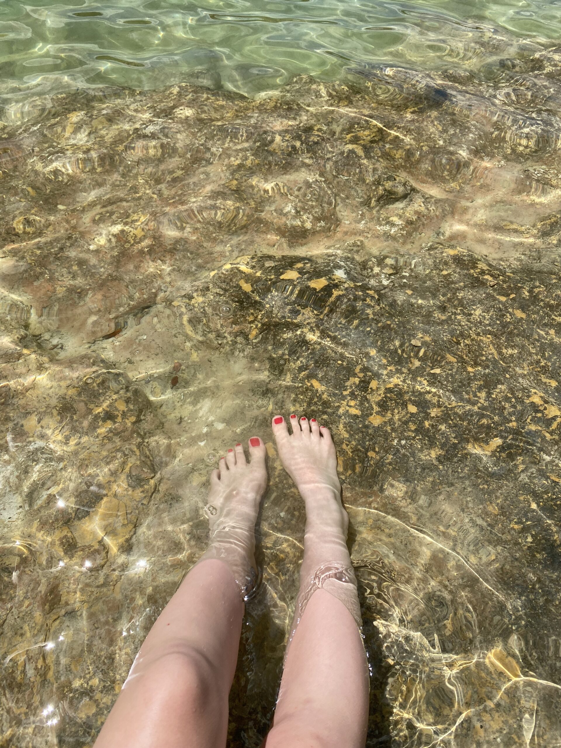 Female feet in the water.
