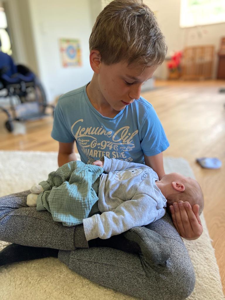 Boy with FXS holding a baby