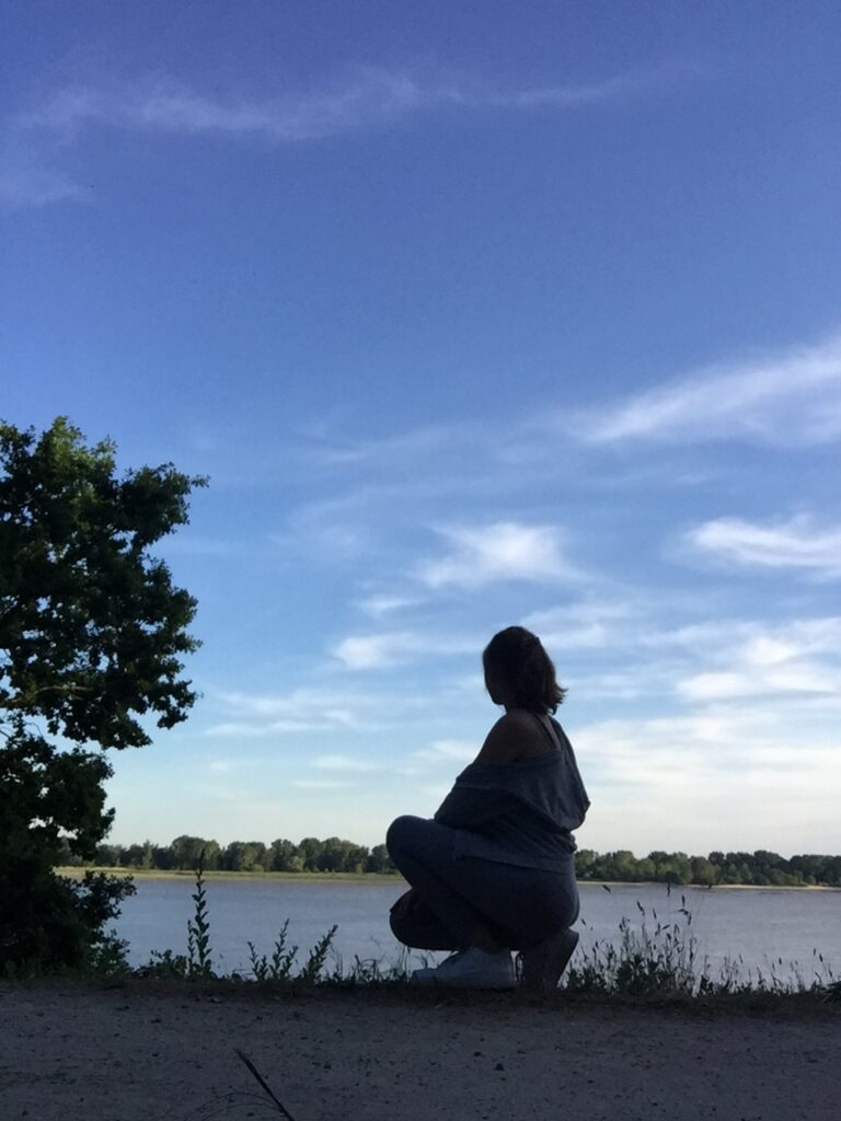 Woman kneels in front of water