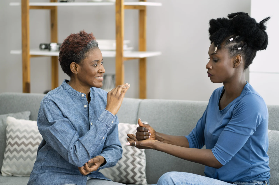An image of two women using sign language to communicate