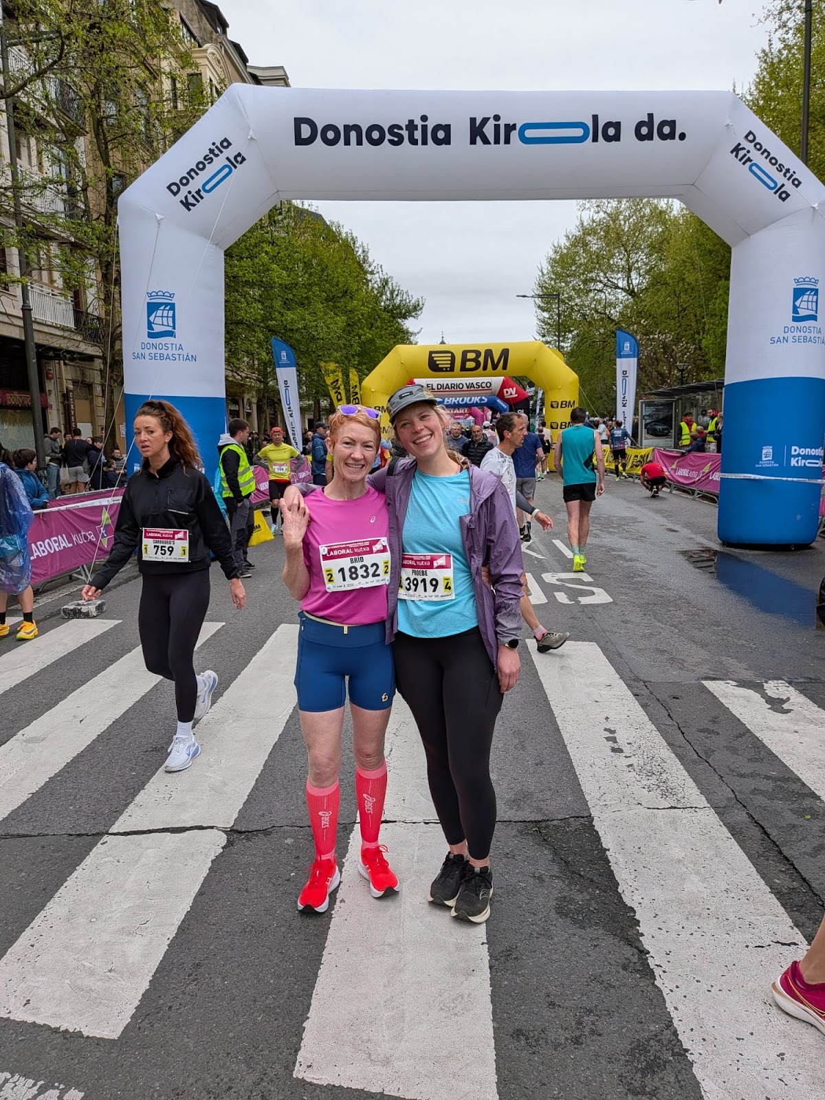 Brid hugging Phoebe in front of the inflatable arches that mark the start