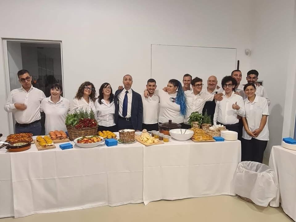 Everyone standing taking a photograph from behind a wonderful buffet and celebrating.